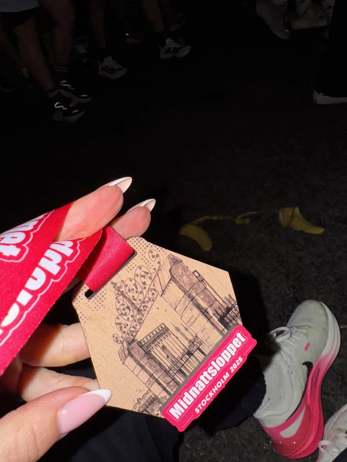 A Midnattsloppet race medal held up after the run